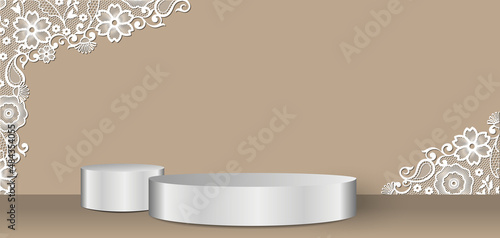 Vitrine pour exposer des produits commerciaux pour un mariage avec 2 podiums argents et de la dentelle sur un fond beige.