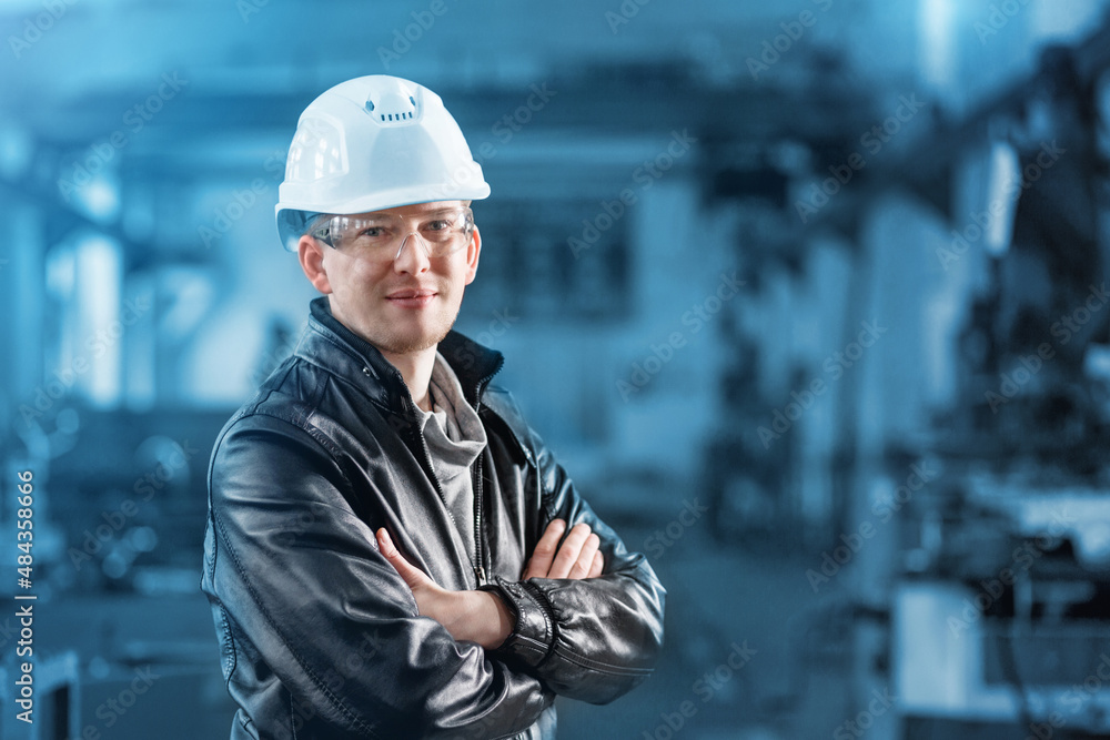 Portrait of a young professional heavy industry engineer working in a white safety helmet Portrait of a young professional heavy industry engineer working in a white safety helmet