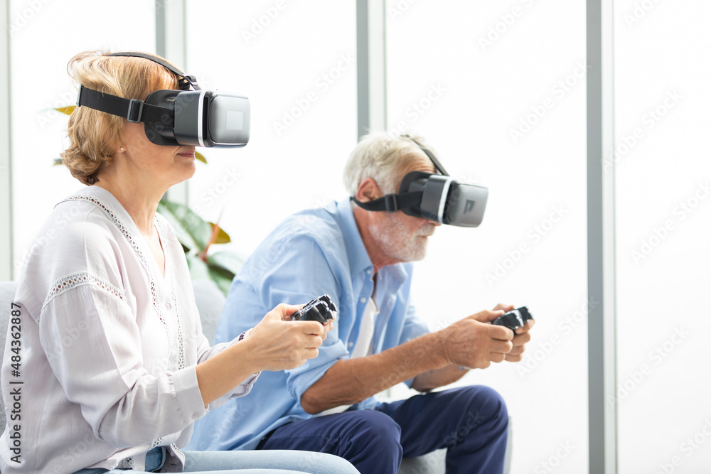 senior couple wearing virtual reality goggles headset (VR) and holding game controller for play a game senior couple wearing virtual reality goggles headset (VR) and holding game controller for play a game