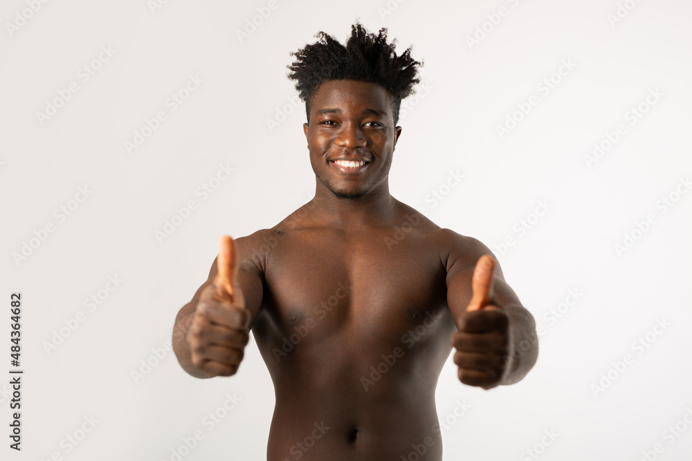 Fototapeta premium cheerful shirtless african male on white background with hand gesture 