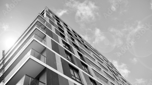 Modern luxury residential flat. Modern apartment building on a sunny day. White apartment building with a blue sky. Facade of a modern apartment building. Black and white.