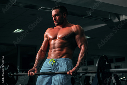 Fotografia Fit man doing biceps lifting barbell
