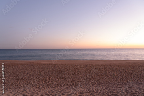 long exposure shot of sandy beach at sunset