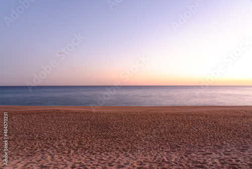 long exposure shot of sandy beach at sunset