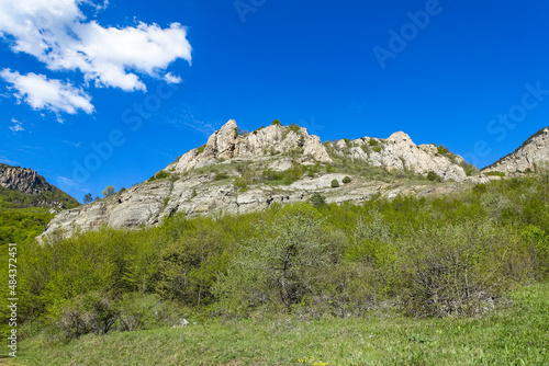 Ancient limestone high mountains of rounded shape in the air haze. The Valley of Ghosts. Demerji. Crimea.