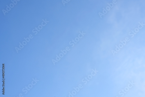 Tiny clouds against clear blue sky background.