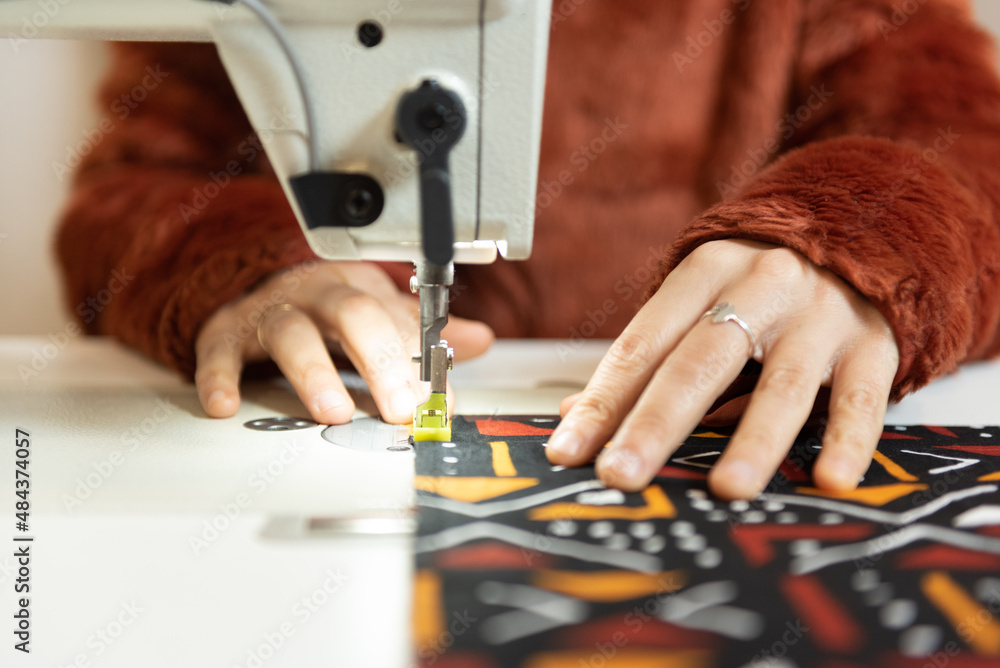 Obraz premium Closeup of hands working on sewing machine.