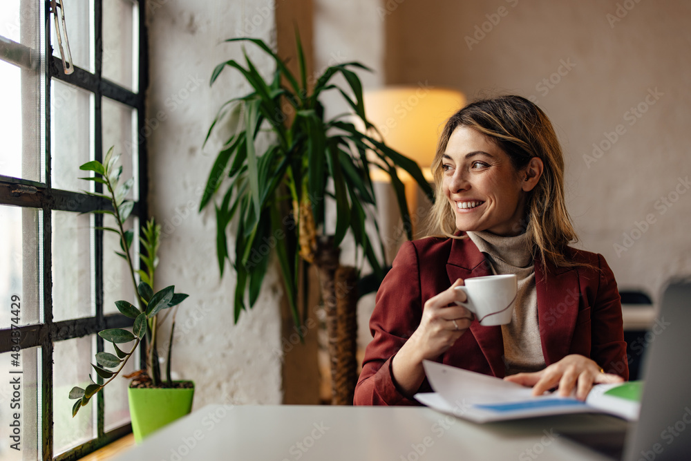 Side profile of smiling girl, studying, while holding a cup of coffee. Side profile of smiling girl, studying, while holding a cup of coffee.