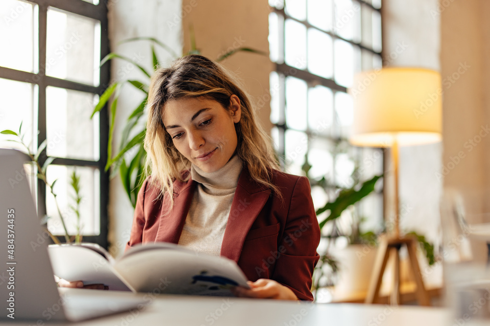 Smiling blonde woman, reading a book on a break from work. Smiling blonde woman, reading a book on a break from work.