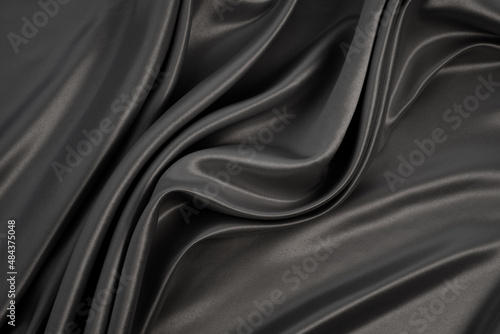 Beautiful elegant wavy grey satin silk luxury cloth fabric texture with grey monochrome background design. Card or banner. Copy space