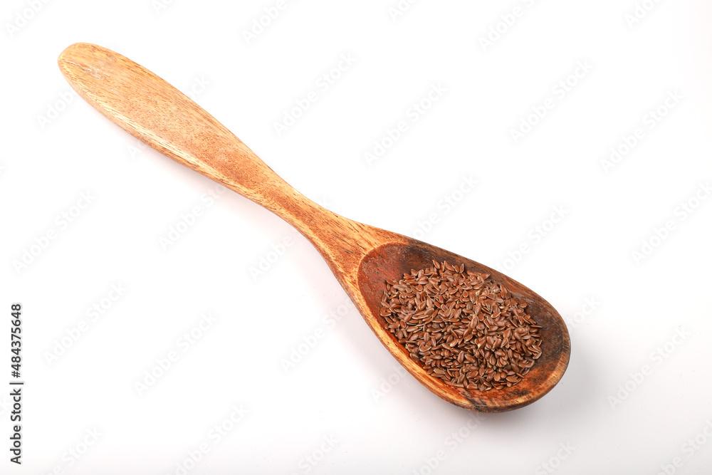 Flax seeds in wooden spoon isolated on white background. Flax seeds in wooden spoon isolated on white background.