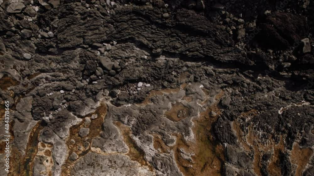 Dark lava rocks texture, revealing ocean coast in Azores Dark lava rocks texture, revealing ocean coast in Azores