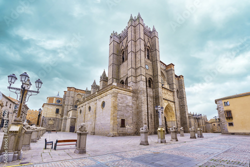 Large gothic cathedral rising into the cloudy winter sky in the city of Avila, Spain.