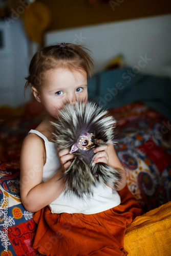 Cute baby toddler girl with fluffy funny fur toy. Homemade toys for children, favorite toys