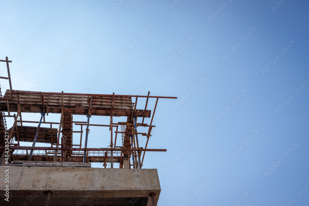 Low angle view of construction site in sunny day with blue sky. House structure construction, building, architecture.