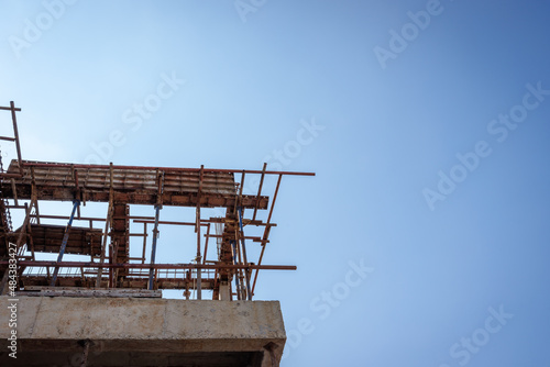 Low angle view of construction site in sunny day with blue sky. House structure construction, building, architecture.