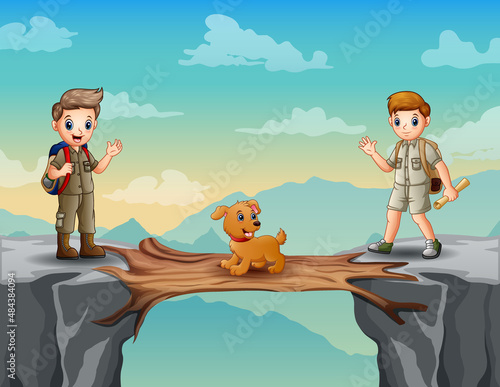 Two boy scouts with a dog crossing a wooden bridge over a cliff