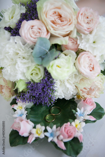 wedding bouquet of the bride in light colors with pink roses, white eustoma with the addition of eucalyptus and wedding rings