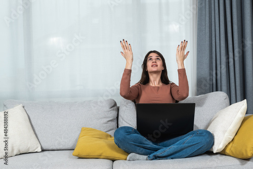 Fotografia Young student or business woman sitting at home covering her ears with hands because she cant study or work on her laptop computer from loud noise coming from apartment above