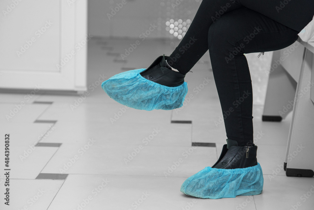 Abstract image with feet in boot covers in a hospital.
