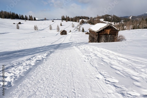 Traumhaft schön gelegene Almen auf den winterlichen Armentara Wiesen am Heiligkreuzkofel in den Dolomiten während einer Winterwanderung 