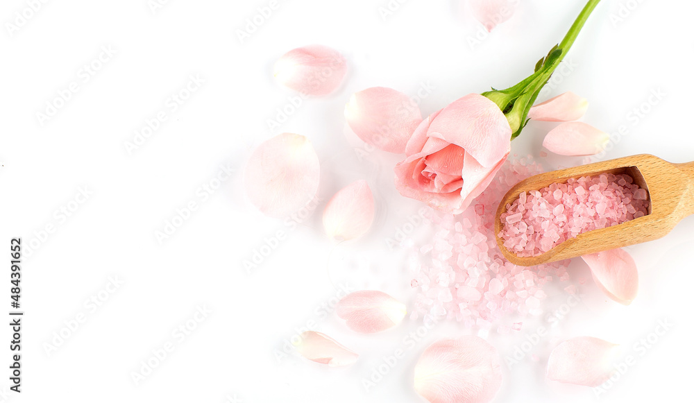 Roses petals and wooden spoon on pink salt, copy space Roses petals and wooden spoon on pink salt, copy space