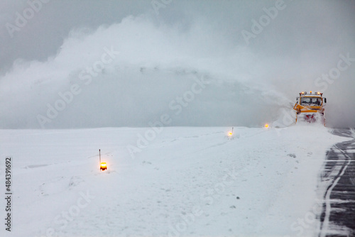 Snow plows on the runway in a snowstorm