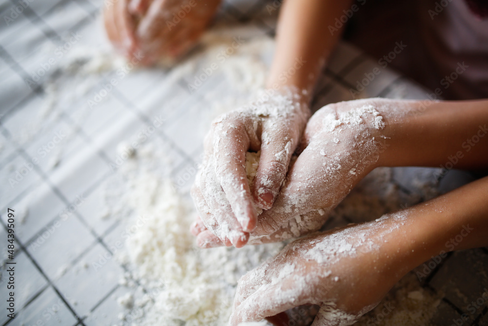 Fototapeta premium Funny children play with artificial snow at home in the kitchen. Educational classes and experiments with children at home. Sensory development and games at home. Snow from starch and shaving foam