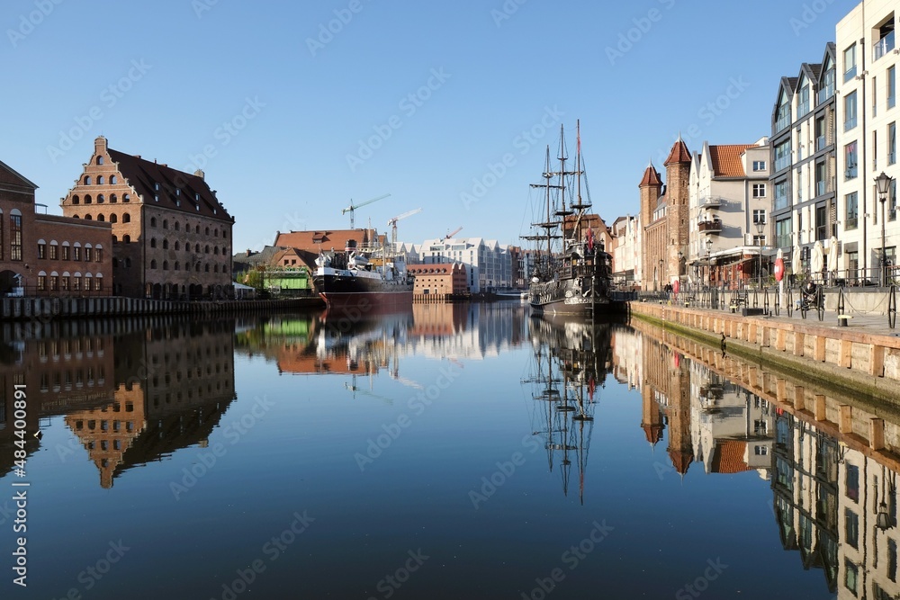Panorama of Old Town and new buildings on Olowianka island in Gdansk. Motlawa canal with ships. Beautiful reflections in water. Poland