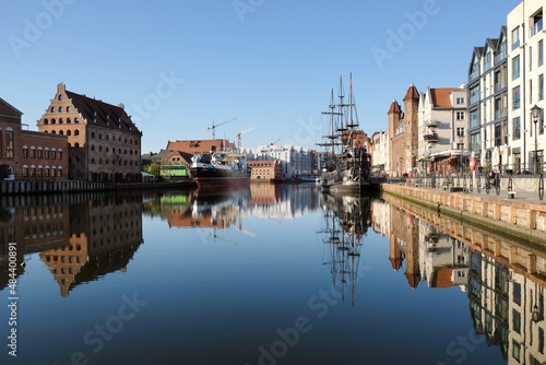 Panorama of Old Town and new buildings on Olowianka island in Gdansk. Motlawa canal with ships. Beautiful reflections in water. Poland