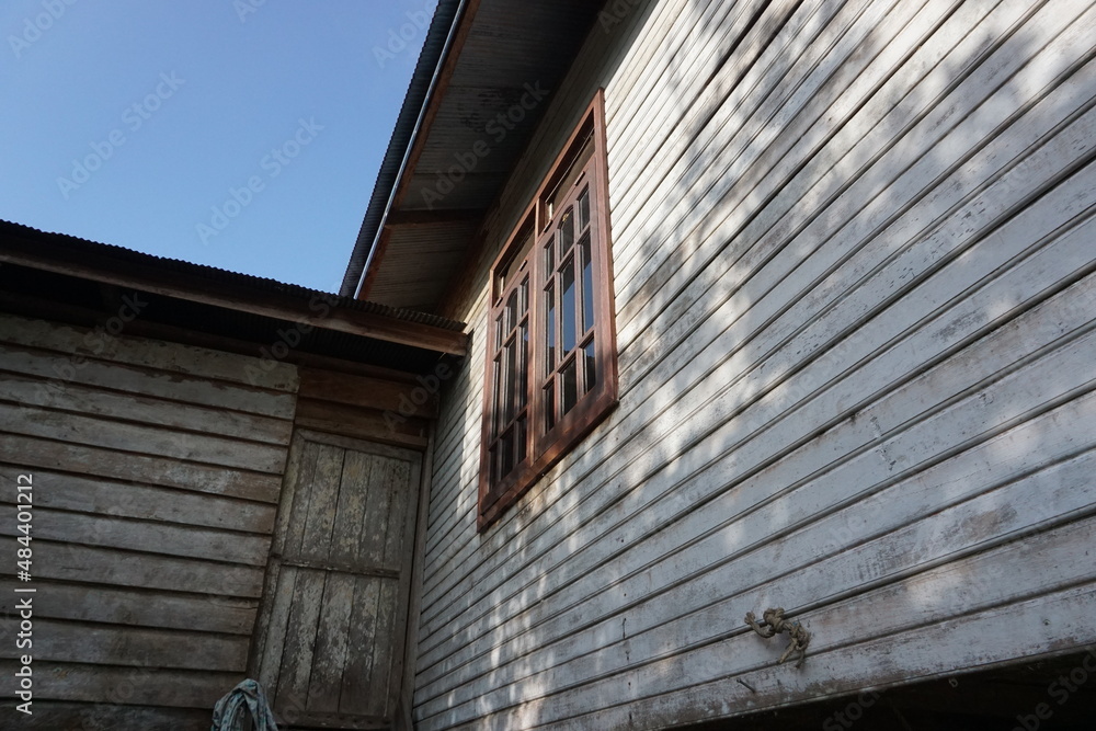 is a traditional house wall in rural Kalimantan, Indonesia, the house is made of wood, there are doors and windows that have glass parts is a traditional house wall in rural Kalimantan, Indonesia, the house is made of wood, there are doors and windows that have glass parts