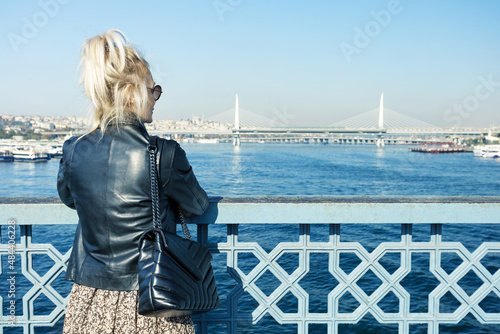 Canvas Mature woman traveler standing on Galata bridge and looks on Bosphorus, Istanbul, Turkey
