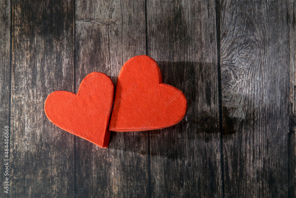 Two red paper hearts are next to each other on a wooden brown table. The day of Valentine. Copy space Two red paper hearts are next to each other on a wooden brown table. The day of Valentine. Copy space