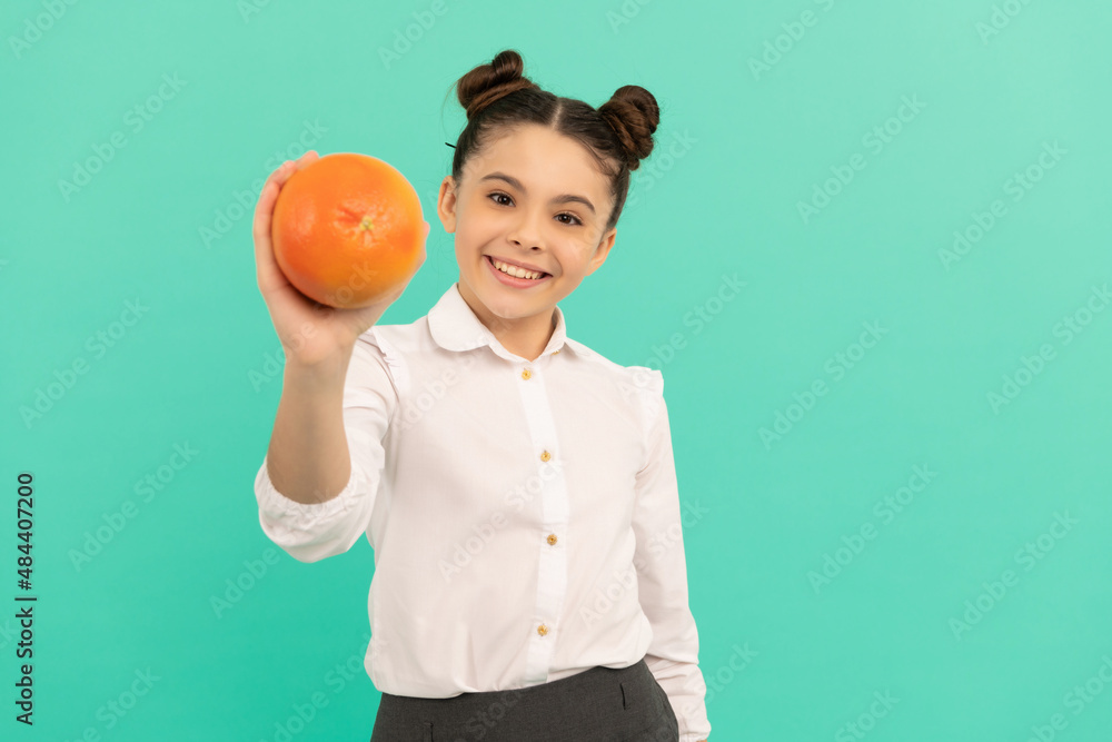 smiling school kid with grapefruit on blue background, dieting smiling school kid with grapefruit on blue background, dieting