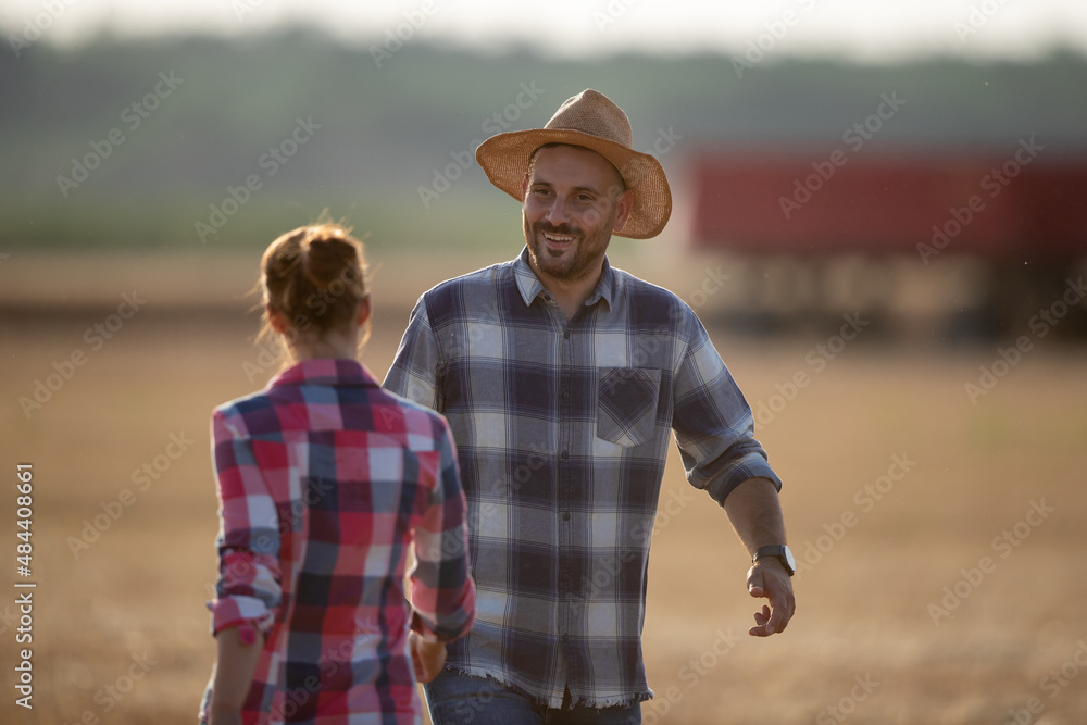 Farmers talking in field in summer time during harvest