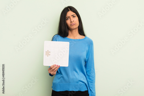 young pretty hispanic woman feeling sad and whiney with an unhappy look and crying. puzzle concept photo