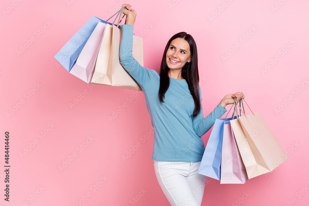 Photo of charming cute woman wear blue shirt rising bargains looking empty space isolated pink color background