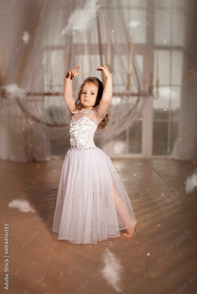 little girl European ballerina in a white airy dress against the background of a huge chandelier in flying feathers for Easter angel little girl European ballerina in a white airy dress against the background of a huge chandelier in flying feathers for Easter angel