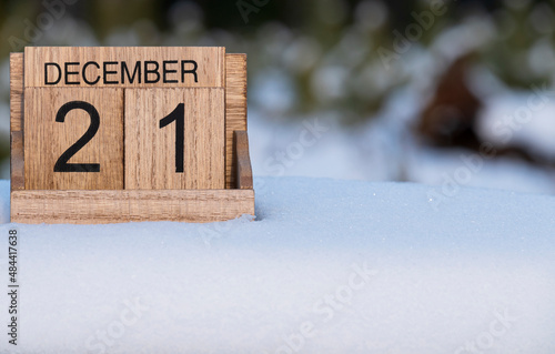 Wooden calendar of December 21 date standing in the snow in nature