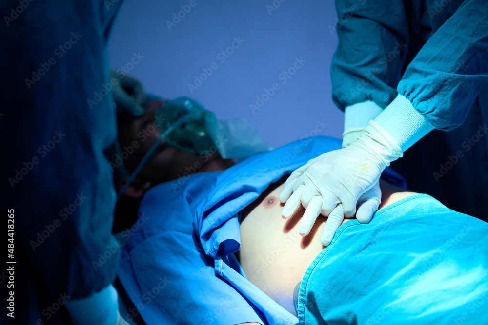 Team of doctors giving CPR to a patient lying on a bed in the emergency room Team of doctors giving CPR to a patient lying on a bed in the emergency room