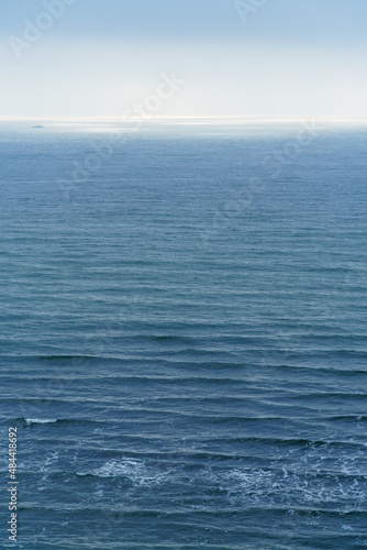 sunlight is reflected in the sea, blue waves and bright light against the sky, view to the horizon