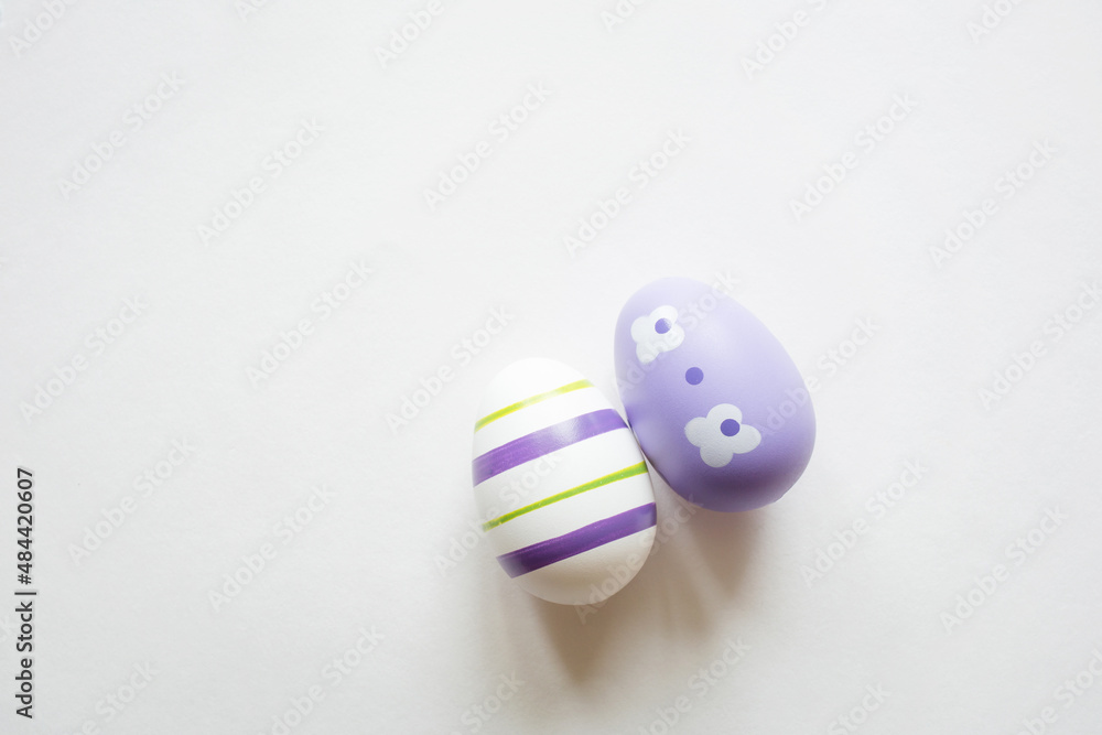 painted easter purple eggs with ornament and decor on white light pastel background. copy space