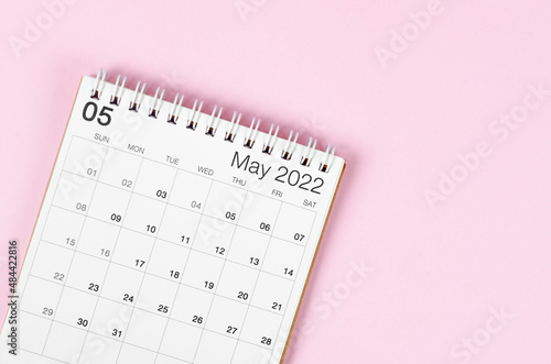 May 2022 desk calendar on pink background with empty space.
