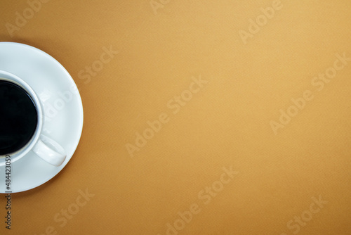 Black coffee in a white coffee cup on a gentle background. Top view, flat lay, copy space. Cafe and bar, barista art concept. Freshly made natural or instant coffee in a cup. Coffee background.