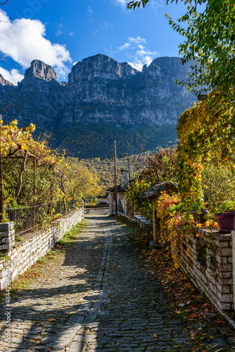 view of traditional architecture  with   stone buildings and background astraka mountain during  fall season in the picturesque village of papigo , zagori Greece photo