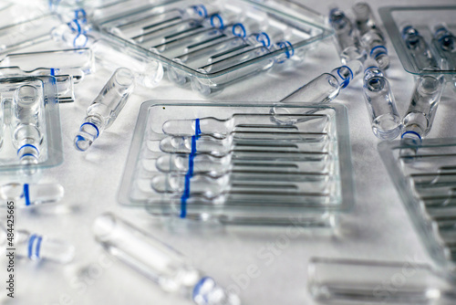 plastic transparent containers with glass ampoules and separate ampoules on a white background