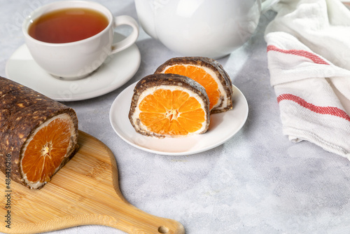 Sweet chocolate roll with tangerine filling and a cup of hot tea.