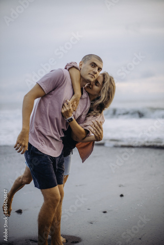 young beautiful couple in love walking at sunset by the ocean, couple relaxing in Bali, vacation in Bali, travel together, hug, love
