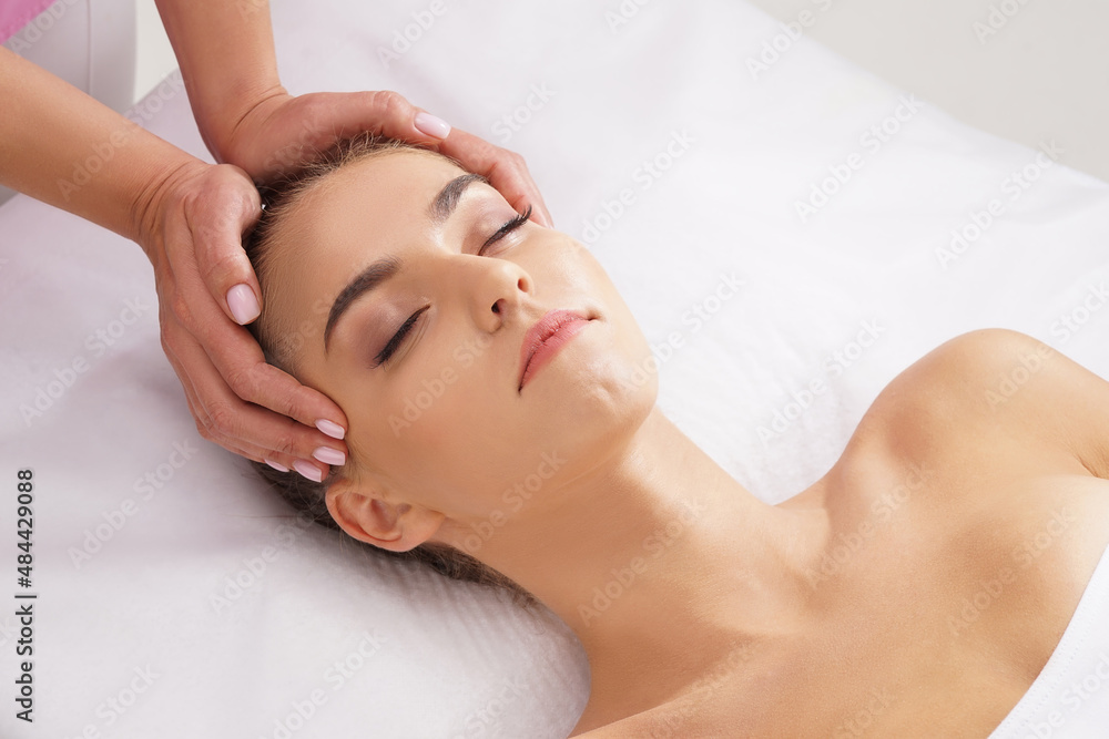 Beautiful, young and healthy woman having face massage in spa salon. Hands of professinal masseur. Spa, health and healing concept. Beautiful, young and healthy woman having face massage in spa salon. Hands of professinal masseur. Spa, health and healing concept.