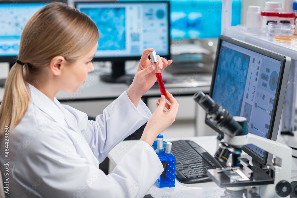 Professional female scientist is working on a vaccine in a modern scientific research laboratory. Genetic engineer workplace. Future technology and science. Professional female scientist is working on a vaccine in a modern scientific research laboratory. Genetic engineer workplace. Future technology and science.